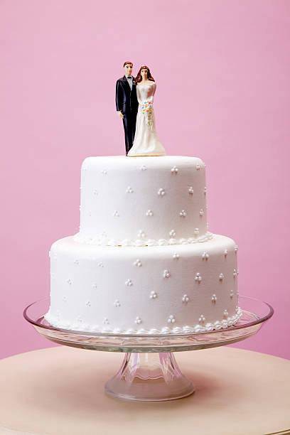 Two-tier wedding cake with bride and groom